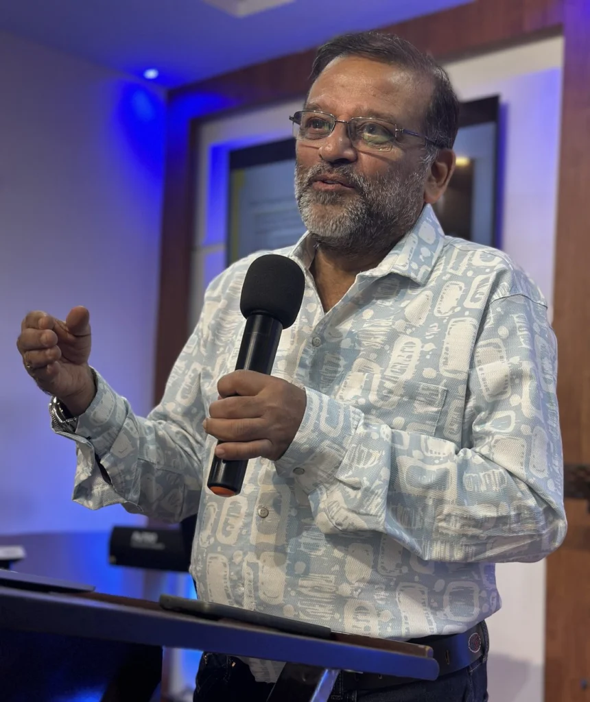 Rev. Dr. J.N. Manokaran speaking with a microphone